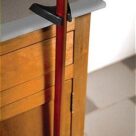 A red and black pole on the side of a dresser.