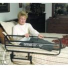 A woman sitting on the bed with an extended rail.